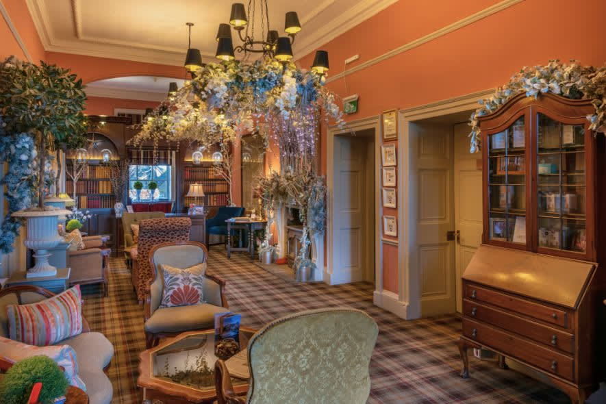 Festive decorations at Washingborough Hall Hotel, with twinkling lights, floral garlands and cosy lounge seating beneath a statement chandelier.