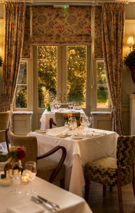 Elegant dining room at Washingborough Hall with twinkling festive lights, white linen tables and a warm seasonal glow.