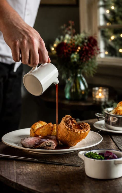 Traditional Sunday roast at Washingborough Hall with rich gravy, seasonal décor, warm candlelight and subtle festive touches.