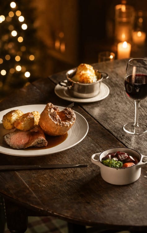 Festive dining at Washingborough Hall featuring a traditional roast dinner, red wine, candlelight and twinkling Christmas lights.
