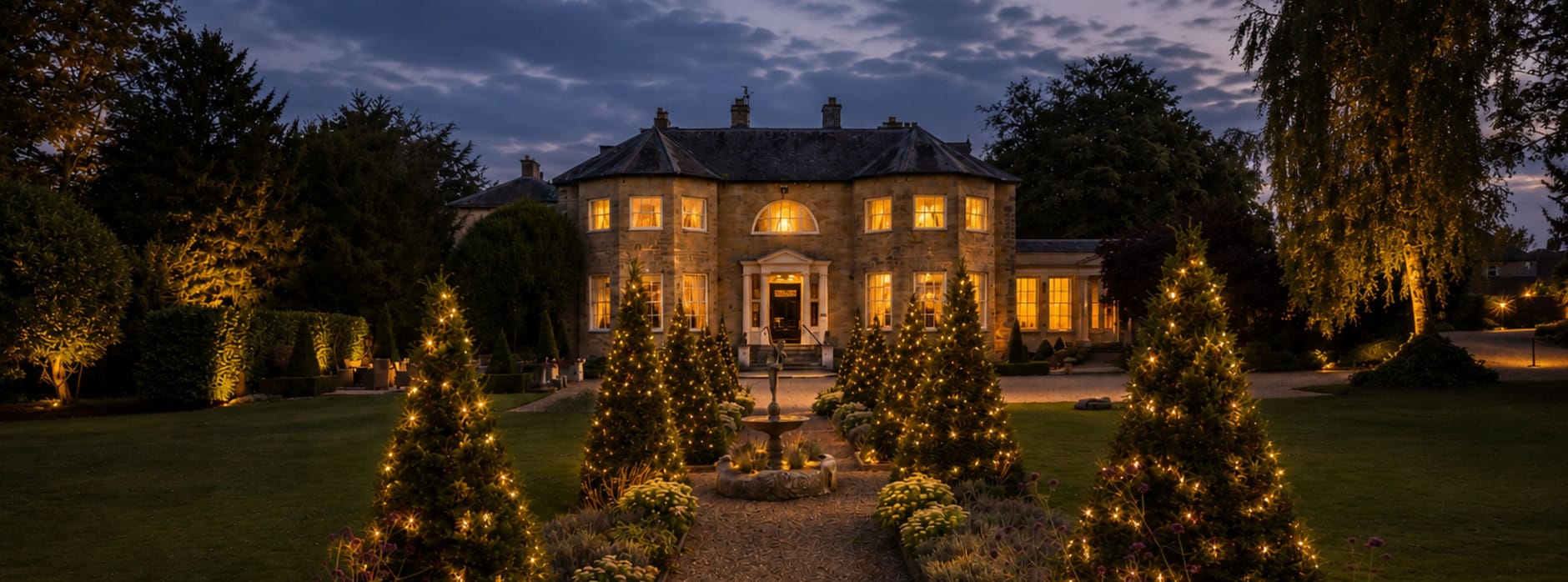 Washingborough Hall at Christmas with twinkling lights, illuminated gardens and the Georgian country house glowing at dusk.